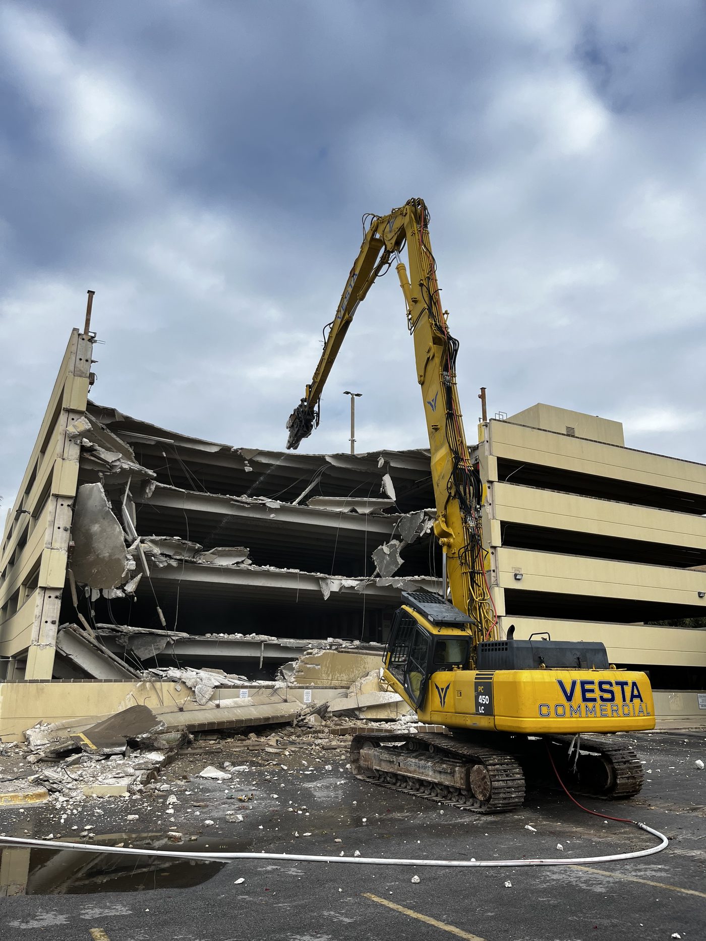 High reach excavator demolishing a concrete parking structure