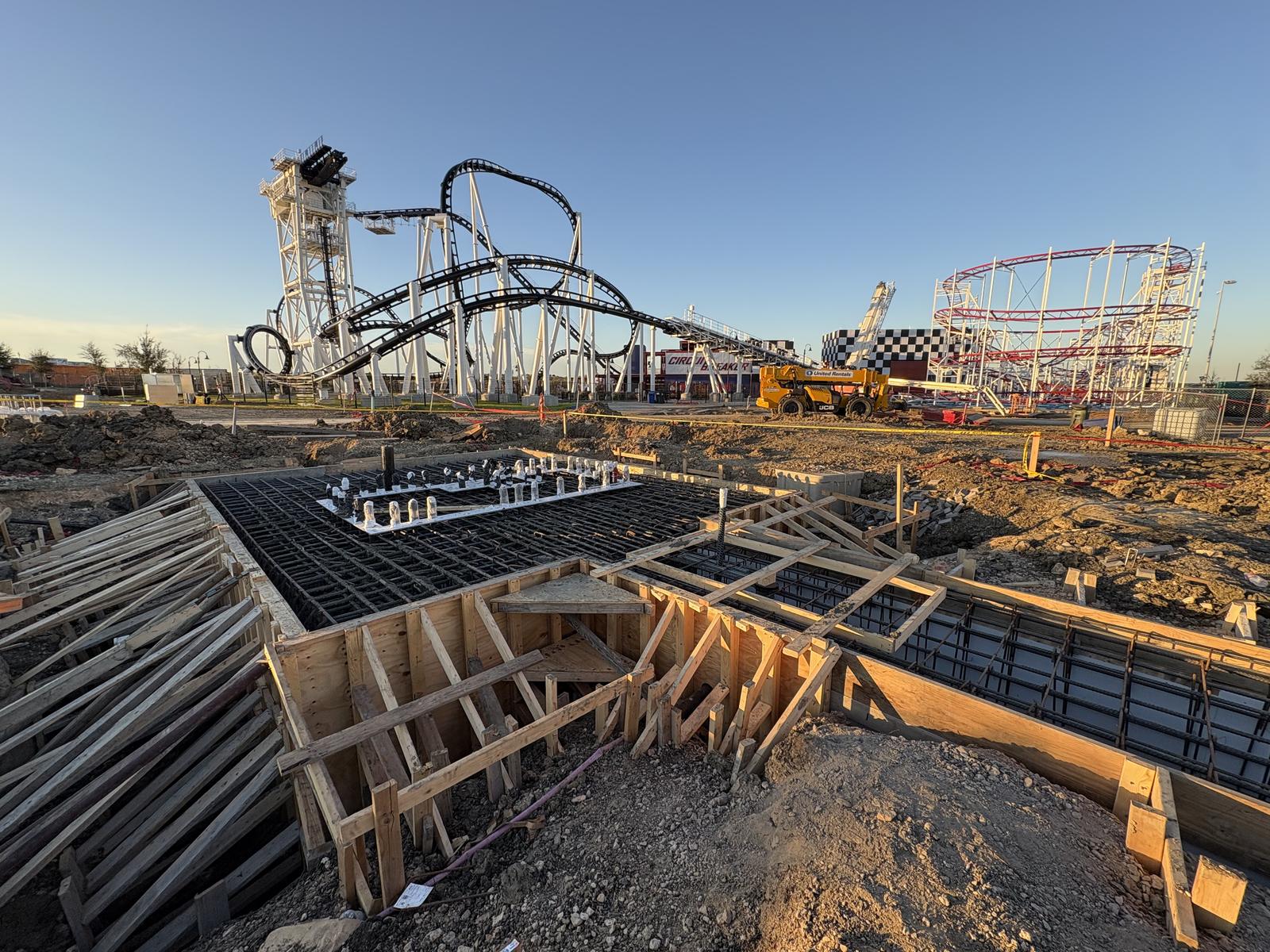 Attraction foundation formwork under construction with COTALAND's roller coasters rising in the background