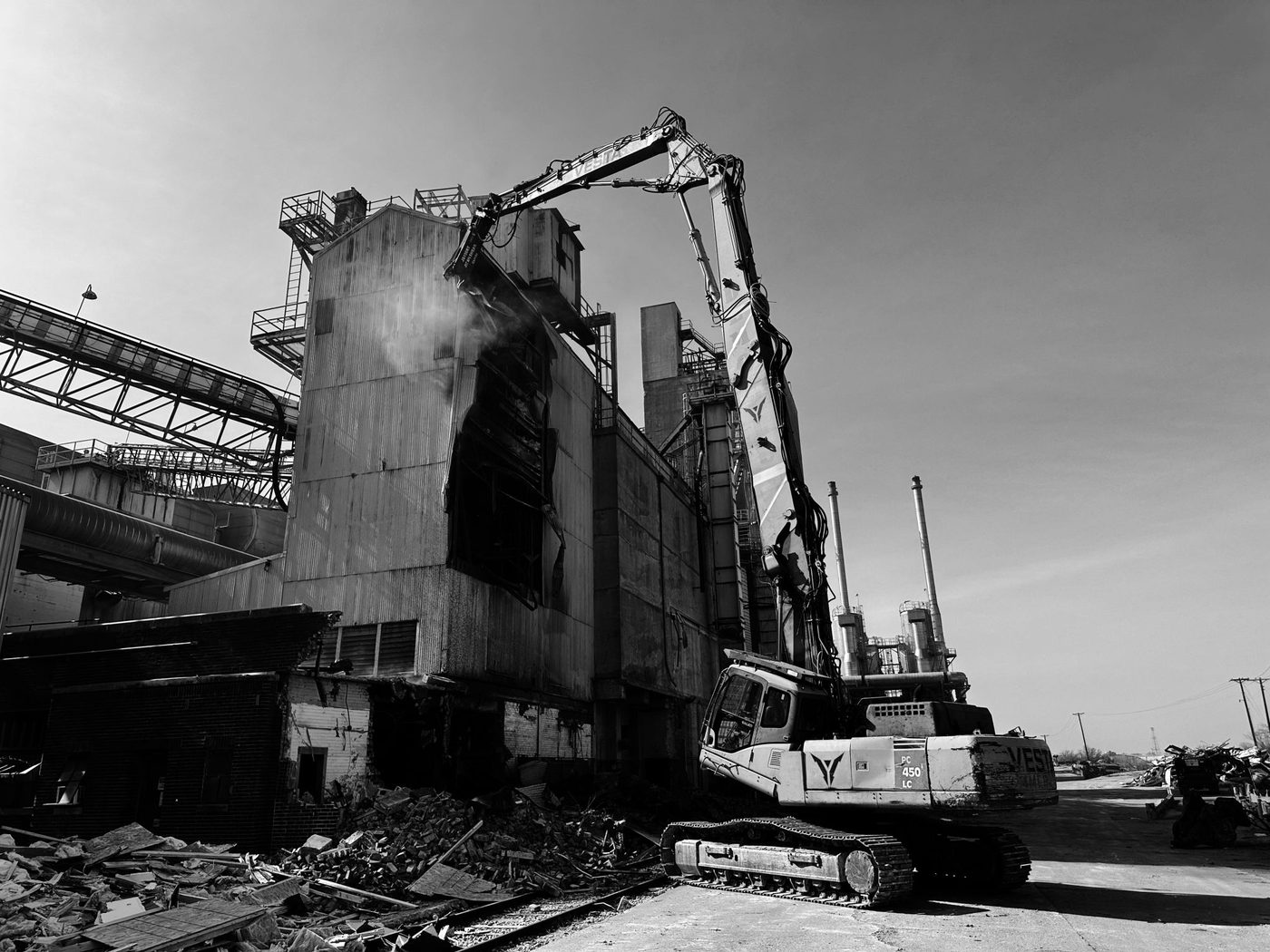 High-reach excavator demolishing the multi-story Waco Bottling Plant